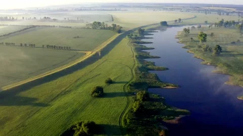 Aerial view of Elbe River winding through meadows beneath morning fog in Germany Stock Footage 342053944
