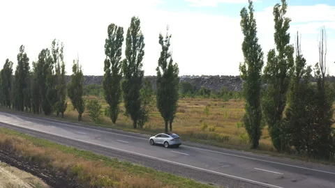 Aerial view of electric car driving on countryside road. New modern vehicle Stock Footage