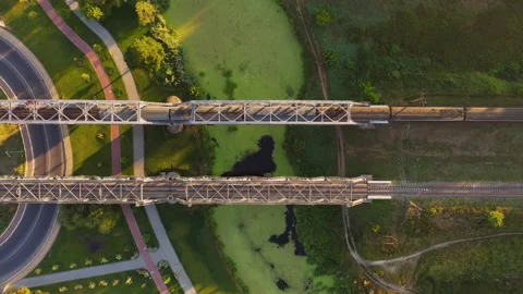 Aerial view of electric train passing the railway bridge across the river. Stock Footage 142399385
