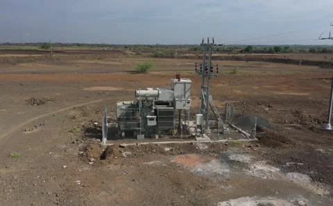 Aerial View of Electrical Power Substation Box with Single Worker Walking Nearby Stock Footage 341709870