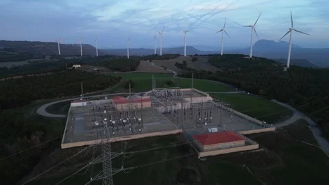 Aerial view of electrical substation and wind turbines at dusk Stock Footage 327274888