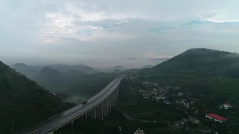 Aerial View of Elevated Highway Through Misty Mountain Valley at Dawn Stock Footage 335461974