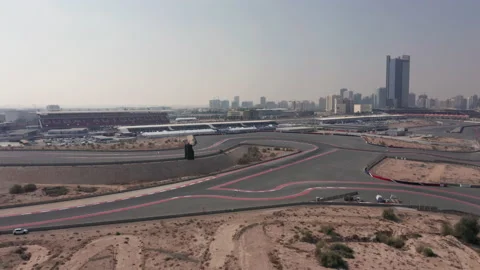 Aerial view of empty Dubai Autodrome race track, grand stand and Dubai skyline Stock Footage 195338902