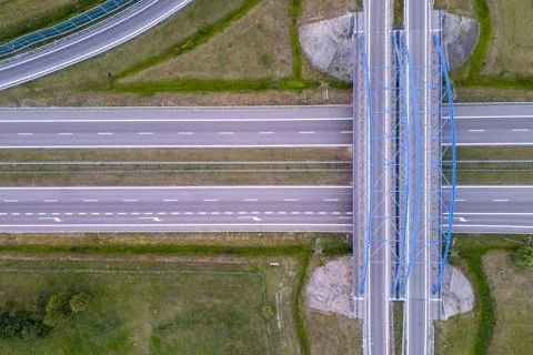 Aerial view of an empty highway intersection with a steel bridge and surrounding Stock Photos