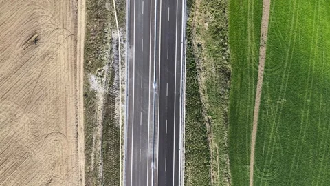 Aerial view of empty highway road through green landscape on sunny spring day Stock Footage 335070047