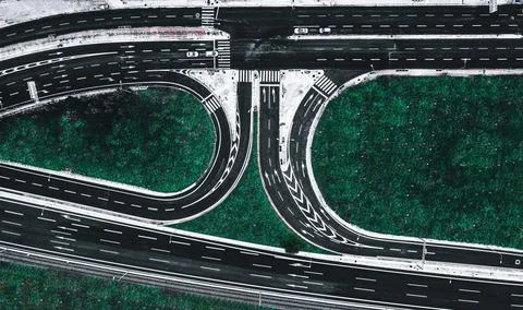 Aerial view of an empty intersection with roads and green trees in Attiki Odos, Stock Photos