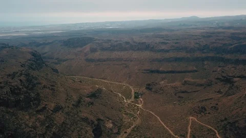 Aerial view of empty mountain valley meandering between rocks and beautiful blue Stock Footage 94122654
