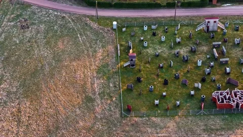 Aerial view of an empty outdoor paintball field with obstacles and structures Video stock 335893533