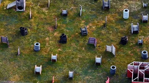 Aerial view of an empty outdoor paintball field with obstacles and barricades Stock Footage 335894041