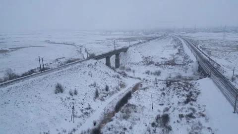 Aerial view of the empty railway tracks with railroad bridge in winter scenery Stock Footage 261386180