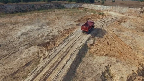 Aerial view of empty red dump truck for sand delivery moving on the sand track Vídeos de archivo 104733006