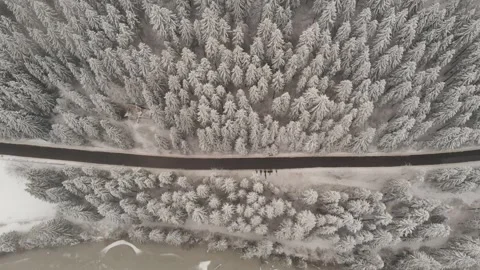 Aerial view of an empty road next to a mountain lake during winter 스톡 동영상 228732376