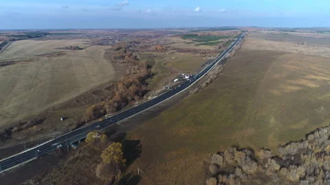 Aerial view of empty road through countryside in autumn afternoon Stock Footage 99250803