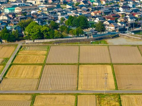 Aerial view of empty road through dry farmland on edge of town Stock Photos