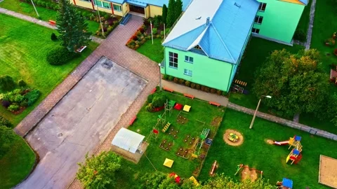 Aerial view of an empty school playground and green yard with colorful equipment Stock Footage 339946917