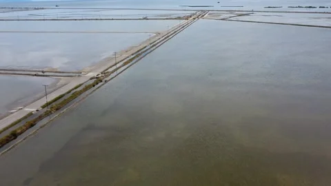 Aerial view of endless straight road crossing flooded lagoon Stock Footage 337048582
