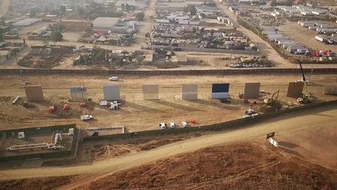Aerial view of engineers working on large walls near a town Stock Footage 114018290