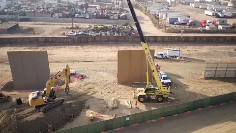 Aerial view of engineers working on large walls near a town 1 Stock Footage 114084054