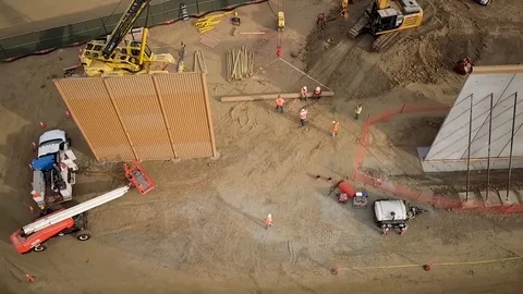 Aerial view of engineers working on large walls near a town 5 Stock Footage 114084104