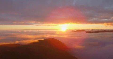 Aerial view of epic low clouds in mountains at sunset. Beautiful flare.  4K UHD. Stock Footage 86056088