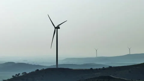 Aerial view epic video of windmill blades and turbines spinning in the mountains Stock Footage 234884601