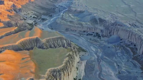 Aerial View of Eroded Desert Landscape with Riverbed at Sunset Xinjiang China Stock Footage 346585920