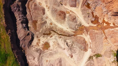 Aerial view of eroded quarry terrain with excavator 動画素材 345153654