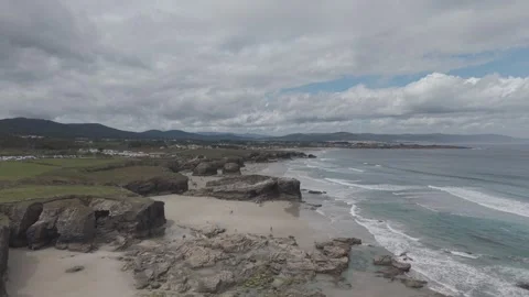 Aerial view of eroded rock formations on a sandy beach at low tide Video stock 342258635