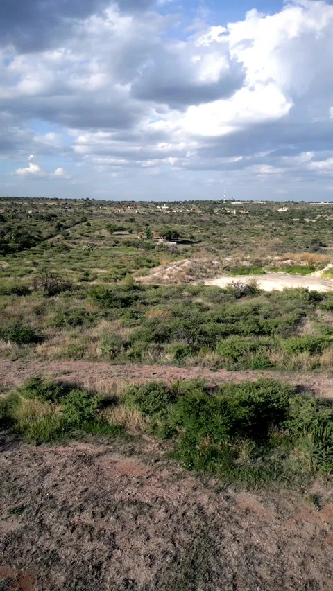 Aerial view of eroded terrain and brush under clouds Stock-Footage 342061392