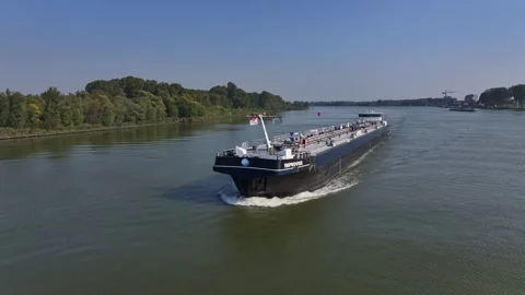 Aerial view establishing of an empty container ship sailing countryside green Stock Footage 294173151