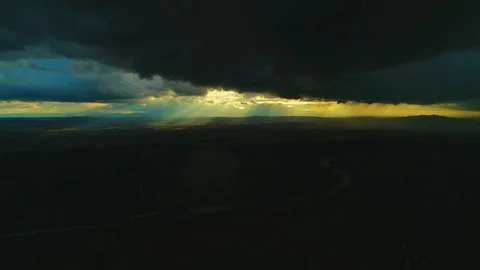 Aerial view of evening sky with sun rays emerging though the dark storm clouds Stock Footage 116883451