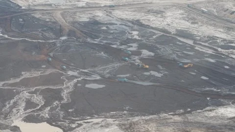Aerial view of excavator activity loading coal into dump trucks at a coal m.. Video stock 332718469