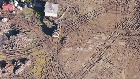 Aerial view of an excavator digging on a muddy construction site Stock Footage 341271197