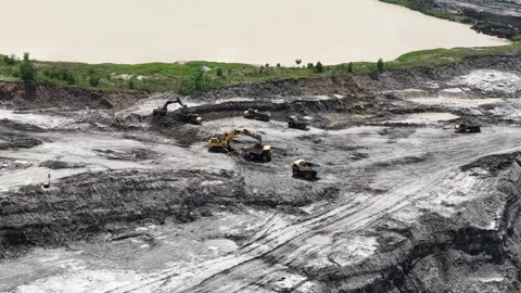 Aerial view of excavator digging soil and loading into dump truck for minin.. Stock Footage 337811993