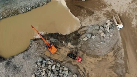 Aerial view of excavator loading dump truck with rocks on riverbank Vidéo 344656629