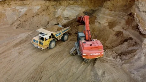 Aerial view excavator loading quarry truck with sand, than truck is leaving Stock Footage 170387988