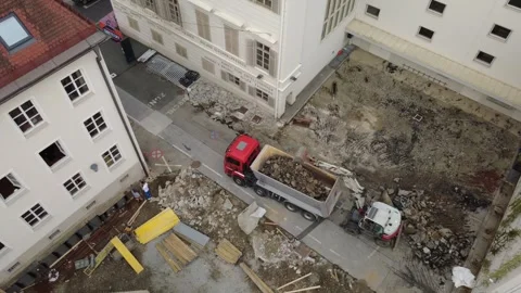 Aerial view of excavator loading rubble onto a truck at a construction site 库存影片 338287942