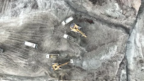 Aerial view of an excavator loading soil into trucks on a huge construction site Stock Footage 232587212