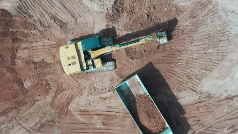 Aerial view excavators and trucks working at construction site Stock Footage