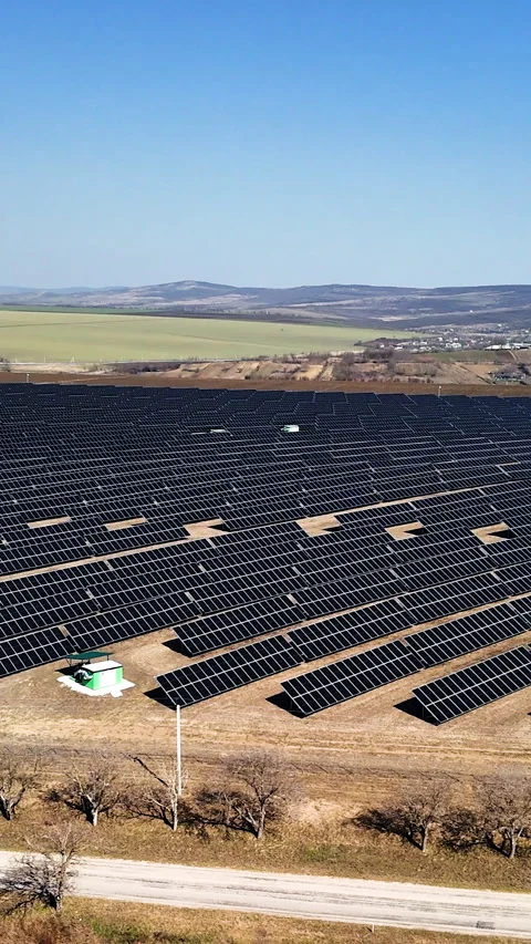 Aerial view of expansive solar panel field with rows of photovoltaic modules Stock Footage 336948530