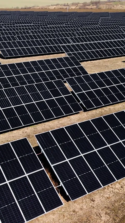 Aerial view of expansive solar panel installation on a sunny day, showcasing Stock Footage 338398797