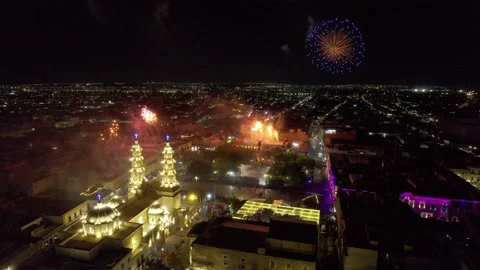 Aerial view of exploding fireworks above an illuminated city Stock Footage 235718451