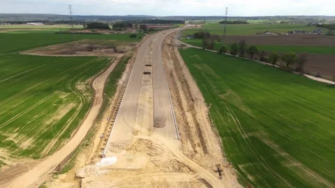 Aerial View of Expressway Construction Site with Roadworks and Farmland Around Stock Footage 315520308