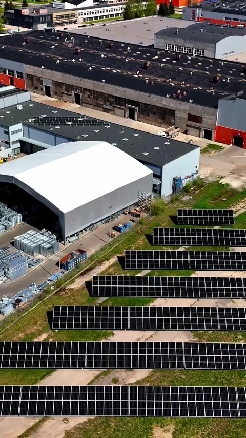 Aerial view of a factory complex with a large solar panel array in the Stock Footage 313096841