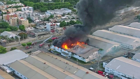 Aerial view of a factory on fire, showcasing the extent of the blaze and Stock Footage 282967123