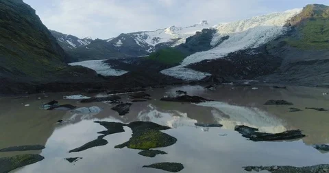 Aerial view of falling glacier with reflection in lake Vidéo 79835884