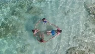 Aerial View Of Family Making Circle In Caribbean Sea Stock Footage