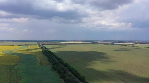 Aerial view of farm fields on the background of the cloudy sky. Stock Photos