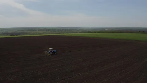 Aerial view of farm machine plowing the land drone footage Stock Footage 114600346