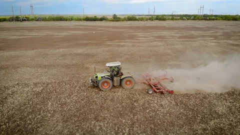 Aerial view of farm tractor with disk harrow cultivates field Video stock 120198616